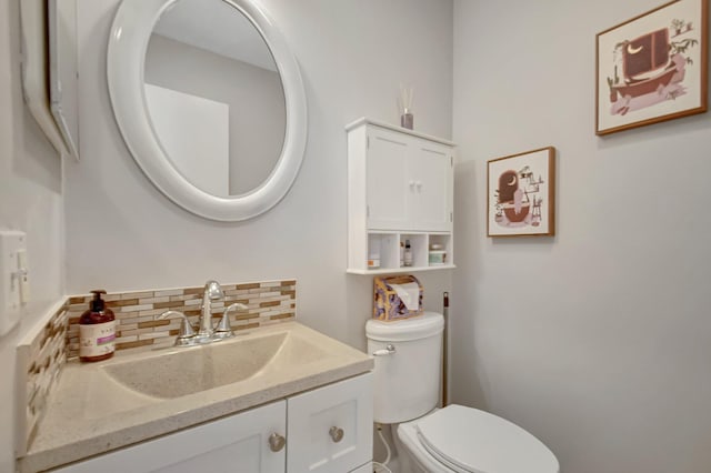 bathroom featuring decorative backsplash, toilet, and vanity