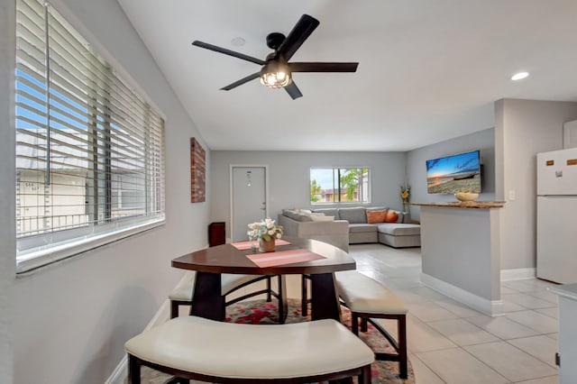 tiled dining room featuring ceiling fan