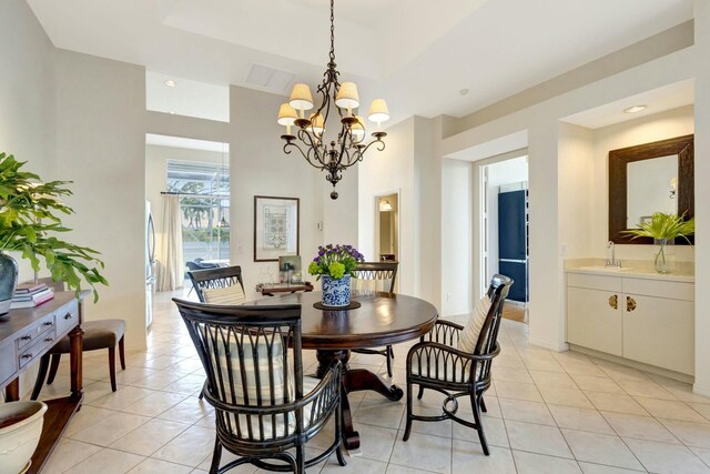 tiled dining room featuring a chandelier and sink