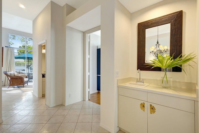 bathroom featuring tile patterned floors, vanity, and an inviting chandelier