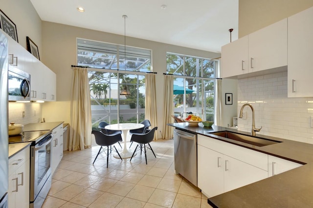 kitchen featuring white cabinets, pendant lighting, stainless steel appliances, and sink