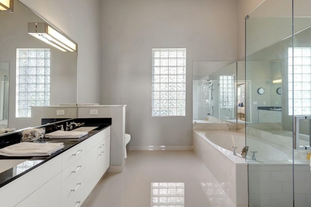 full bathroom featuring toilet, shower with separate bathtub, tile patterned floors, and a wealth of natural light