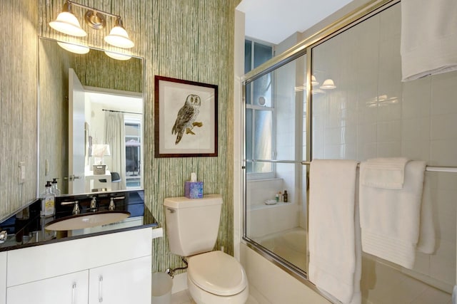 full bathroom featuring vanity, toilet, and bath / shower combo with glass door