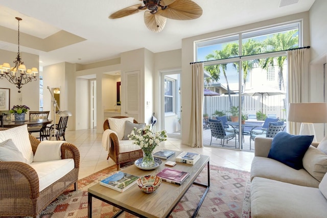 living room with light tile patterned flooring and ceiling fan with notable chandelier