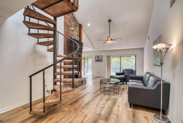 living room featuring ceiling fan, high vaulted ceiling, and light wood-type flooring