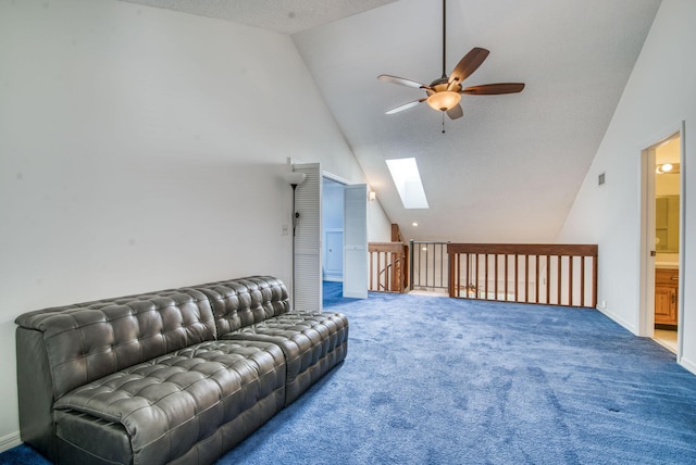 carpeted living room with vaulted ceiling with skylight, ceiling fan, and a textured ceiling