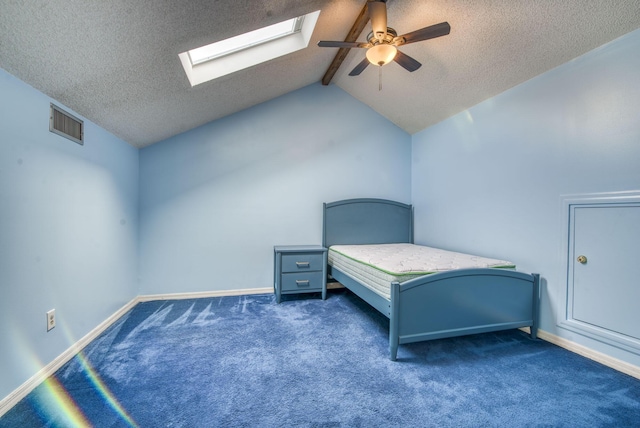 unfurnished bedroom with a textured ceiling, ceiling fan, dark carpet, and lofted ceiling with skylight