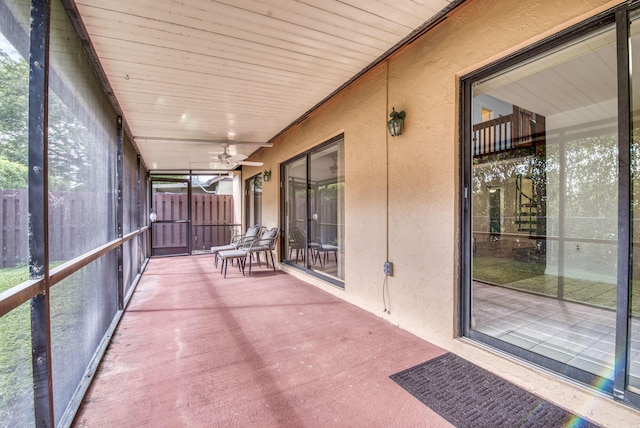 unfurnished sunroom featuring ceiling fan