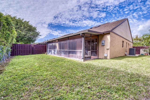 rear view of house featuring a sunroom and a yard