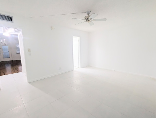 empty room with ceiling fan and light tile patterned floors