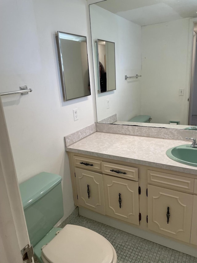 bathroom featuring tile patterned flooring, vanity, and toilet