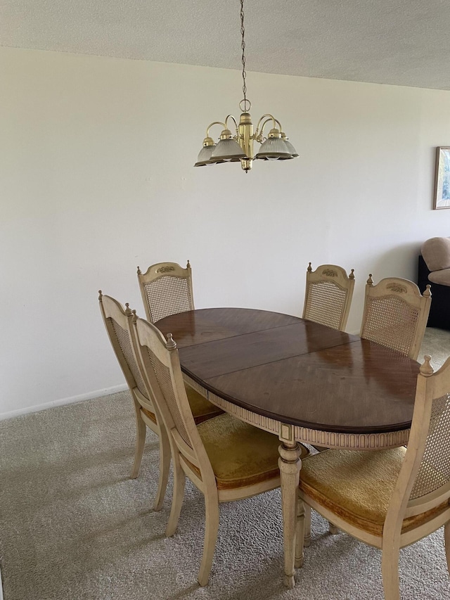 dining room featuring carpet flooring, a chandelier, and a textured ceiling