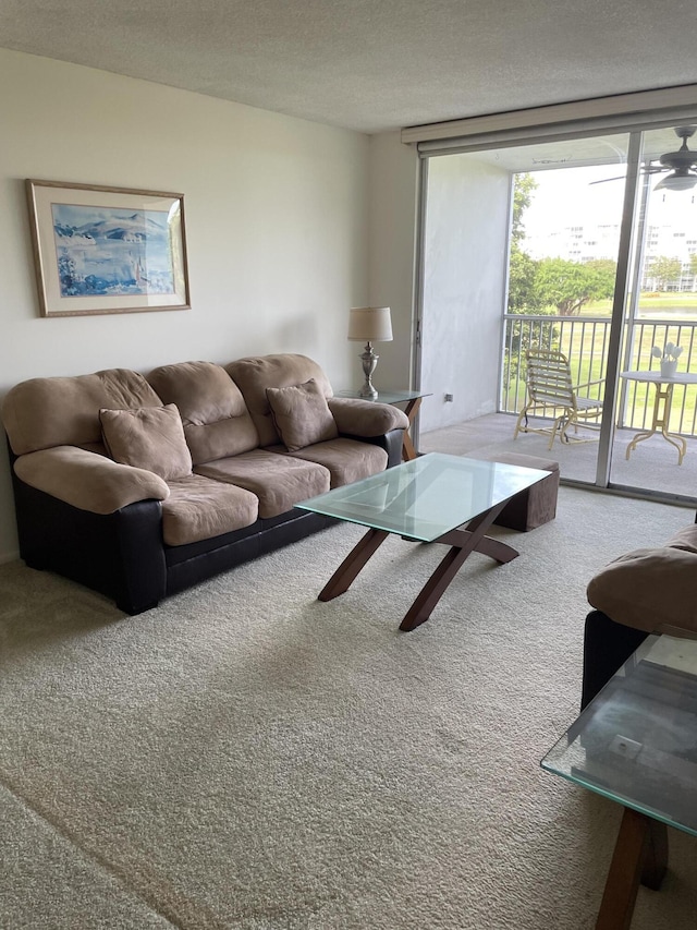 carpeted living room featuring ceiling fan, floor to ceiling windows, and a textured ceiling