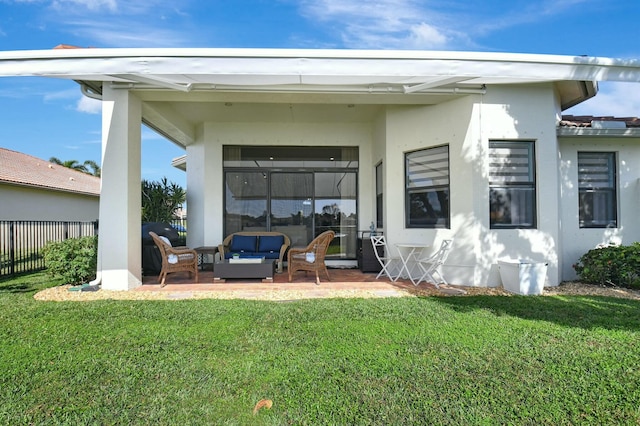 rear view of property featuring a lawn, a patio, and an outdoor hangout area