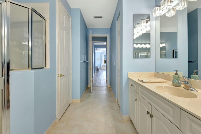 bathroom featuring tile patterned flooring, vanity, and walk in shower