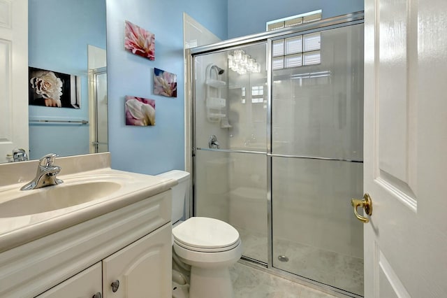 bathroom with a shower with door, vanity, and toilet