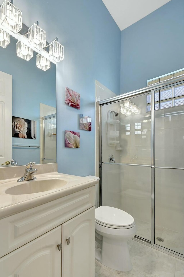 bathroom with vanity, toilet, and a shower with shower door