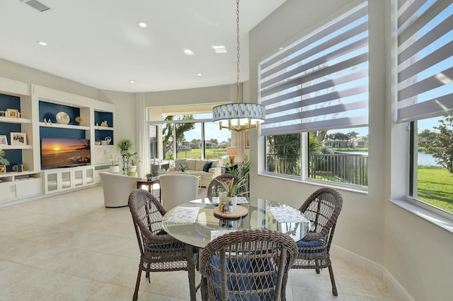 dining space with built in shelves, plenty of natural light, and light tile patterned flooring