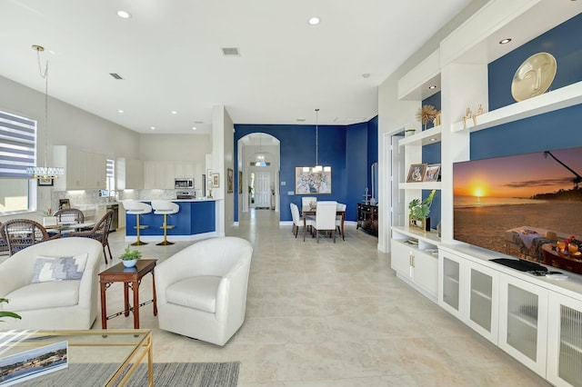 tiled living room with an inviting chandelier