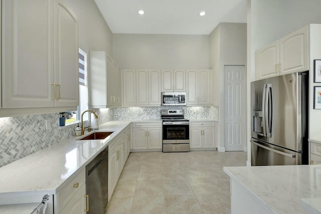 kitchen featuring white cabinetry, light stone countertops, and stainless steel appliances