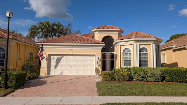 mediterranean / spanish-style home with a garage and a front lawn