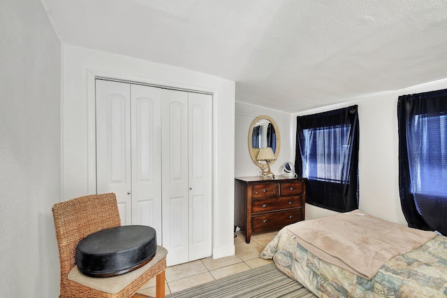 bedroom with light tile patterned floors, a closet, and a textured ceiling