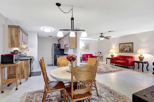 tiled dining space with ceiling fan