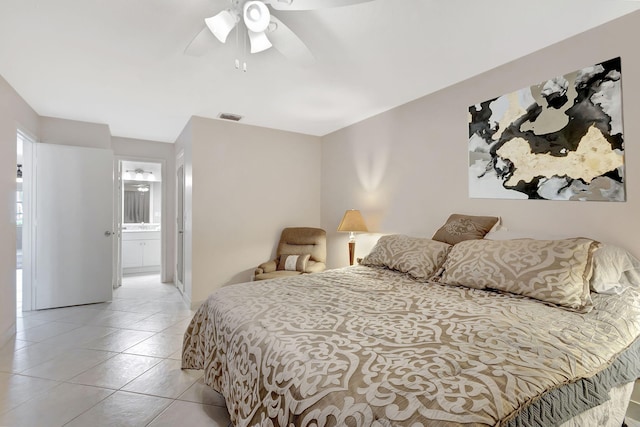 tiled bedroom featuring ensuite bath and ceiling fan