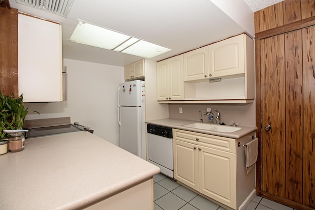 kitchen featuring light tile patterned floors, white appliances, and sink