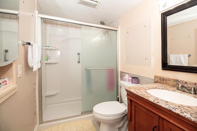 bathroom featuring vanity, toilet, and walk in shower