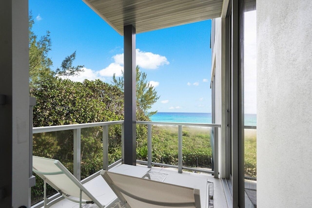 balcony featuring a water view and a view of the beach