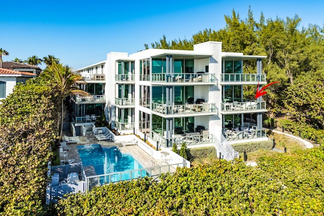 rear view of house with a balcony and a patio