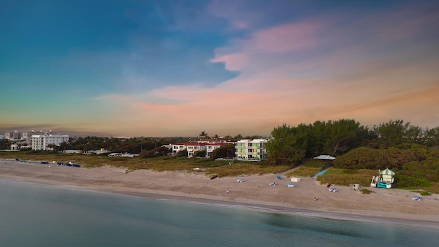 aerial view at dusk with a beach view and a water view