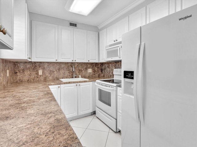 kitchen featuring tasteful backsplash, white appliances, sink, white cabinetry, and light tile patterned flooring