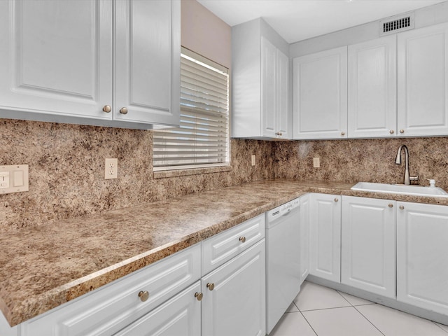 kitchen with white dishwasher, sink, decorative backsplash, light tile patterned flooring, and white cabinetry