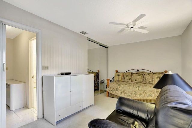 bedroom featuring light tile patterned floors, a closet, and ceiling fan