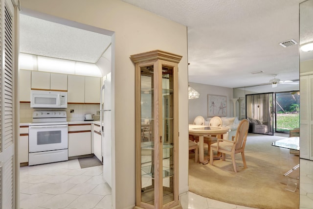 kitchen with tasteful backsplash, a textured ceiling, white appliances, light colored carpet, and ceiling fan