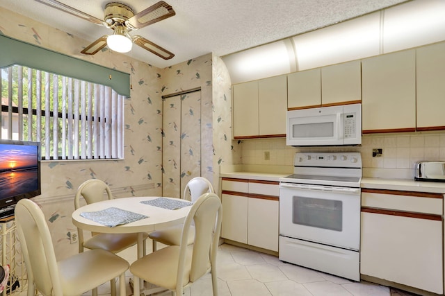 kitchen with decorative backsplash, cream cabinets, and white appliances