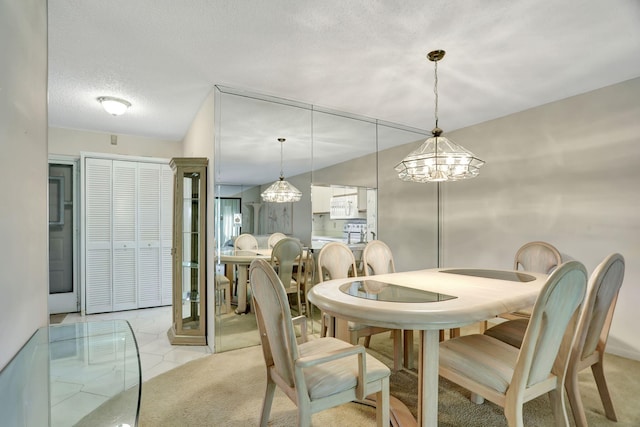 dining space with light tile patterned flooring, a textured ceiling, and an inviting chandelier