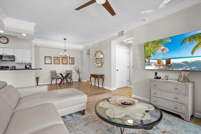 living room with crown molding, light hardwood / wood-style flooring, ceiling fan with notable chandelier, and a textured ceiling