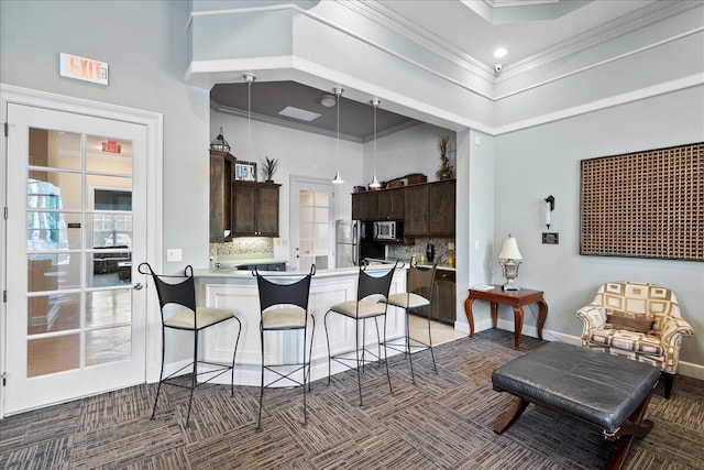 kitchen with dark colored carpet, backsplash, kitchen peninsula, a towering ceiling, and a breakfast bar area