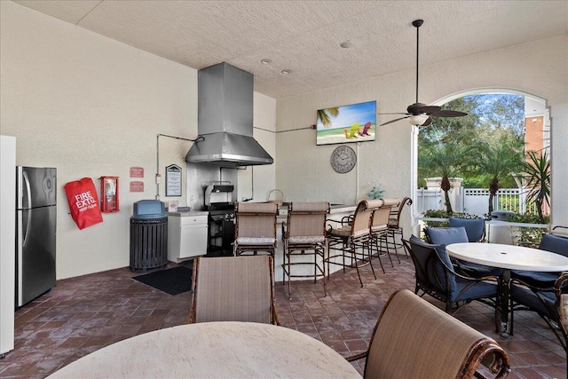 view of patio with ceiling fan and a bar