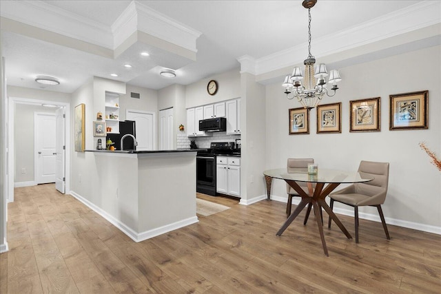 kitchen featuring white cabinets, black appliances, decorative light fixtures, and a notable chandelier