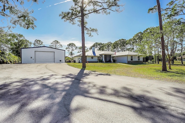 view of front of home with an outbuilding, a front yard, and a garage