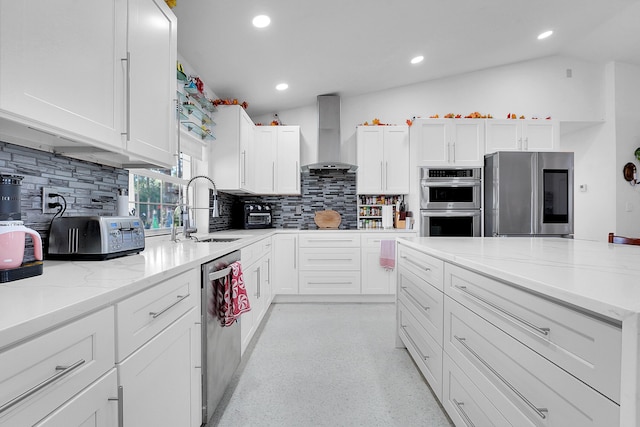 kitchen with white cabinets, wall chimney range hood, and stainless steel appliances