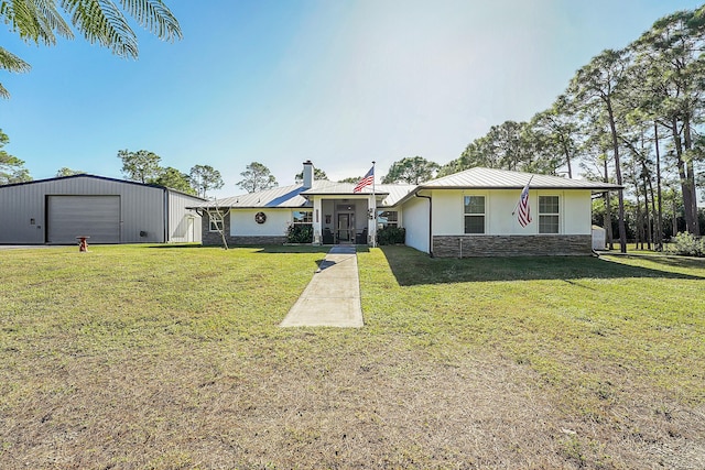 view of front of house with a garage, an outbuilding, and a front yard