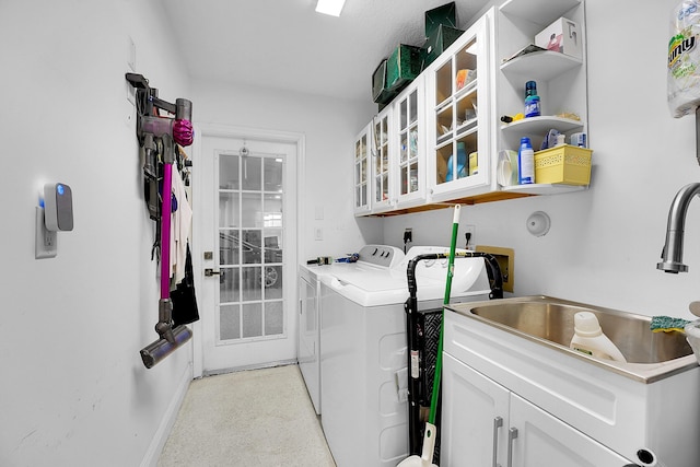 laundry room with cabinets, independent washer and dryer, and sink