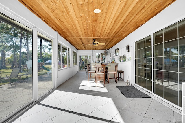 unfurnished sunroom featuring ceiling fan and wooden ceiling