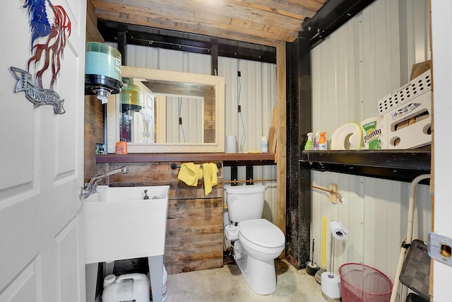 bathroom featuring wood ceiling, wood walls, concrete floors, and toilet