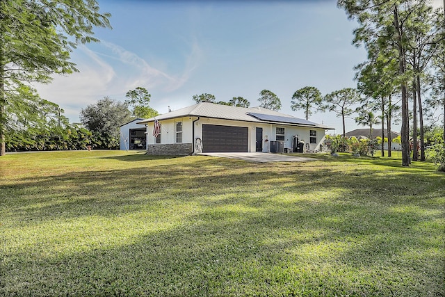 ranch-style house featuring solar panels, a garage, and a front yard